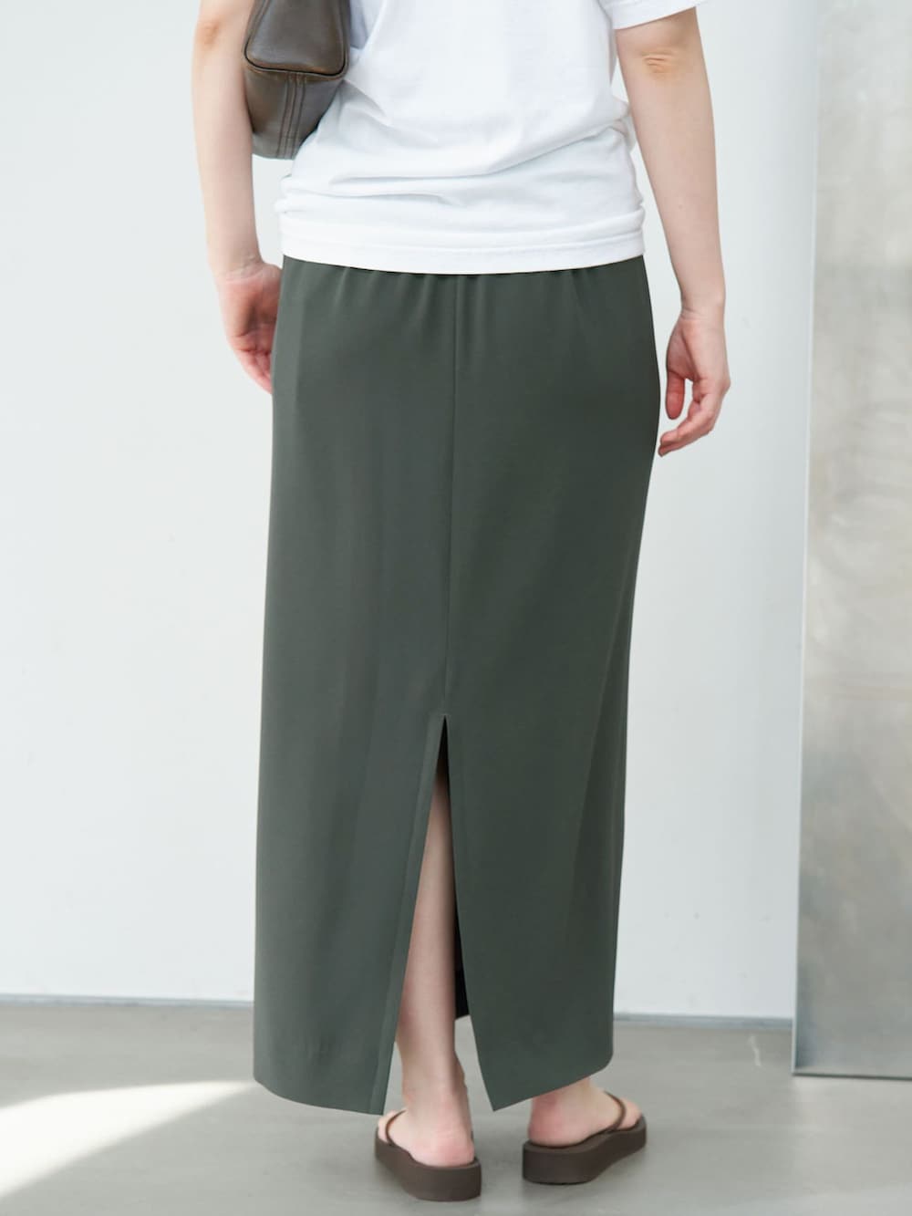 グリーン系のスカート、ホワイト系のTシャツ/カットソーを着用したレディースの夏コーディネートの8枚目の写真