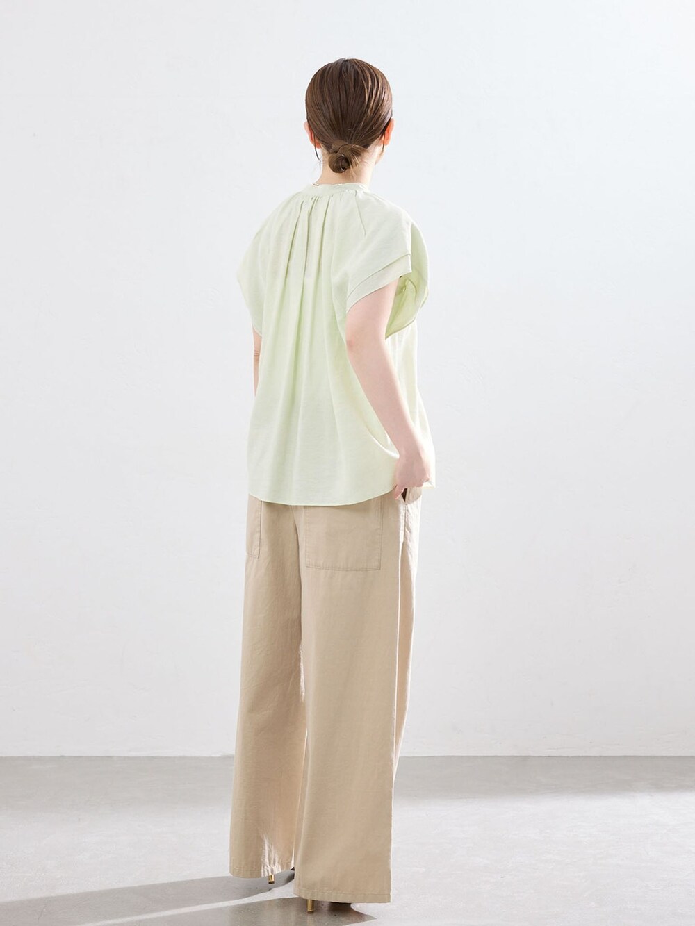 ベージュ系のその他パンツ、グリーン系のシャツ/ブラウス、ホワイト系のサンダルを着用したレディースの春コーディネートの3枚目の写真