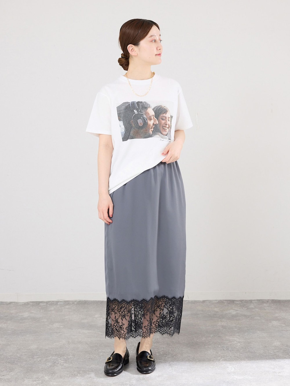 グレー系のスカート、ホワイト系のTシャツ/カットソー、ブラック系のローファーを着用したレディースの春コーディネートの2枚目の写真