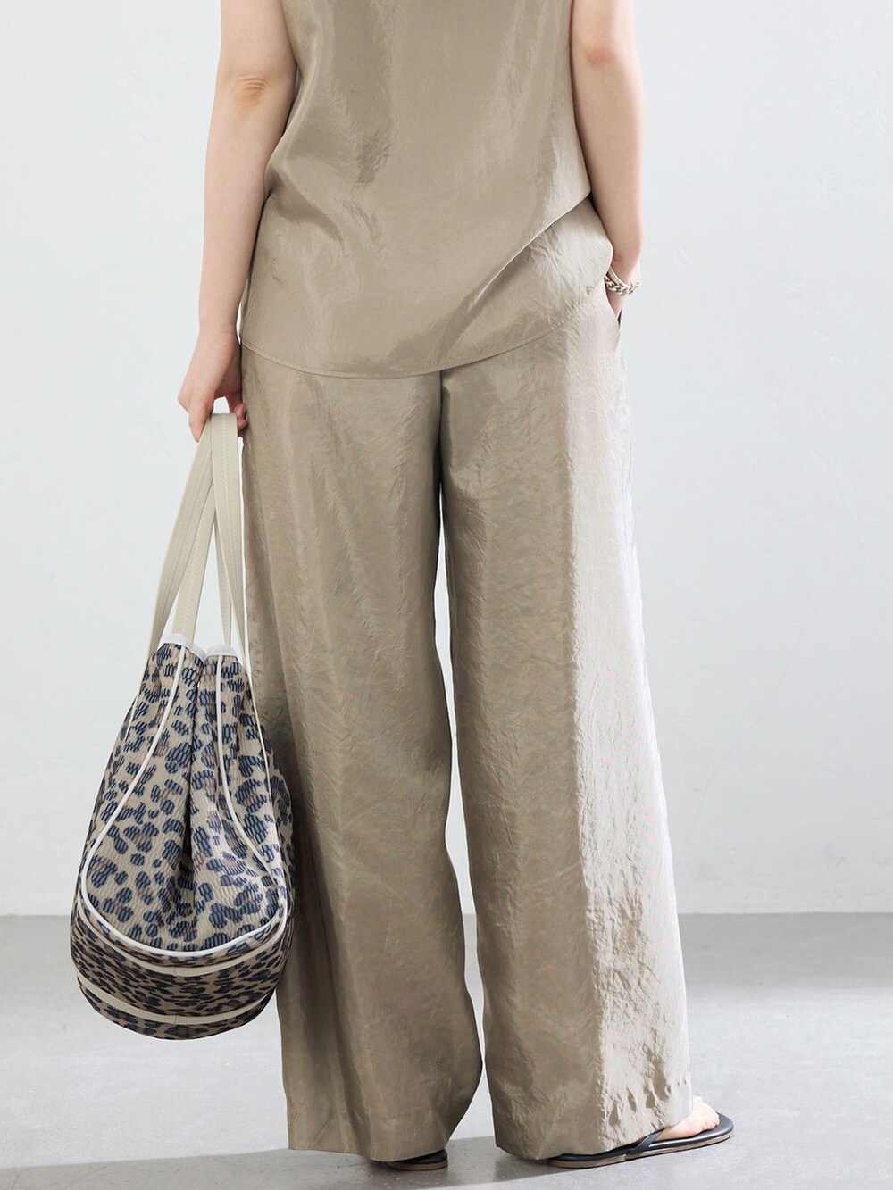 ベージュ系のその他パンツ、ベージュ系のシャツ/ブラウス、ブラウン系のトートバッグを着用したレディースの夏コーディネートの7枚目の写真