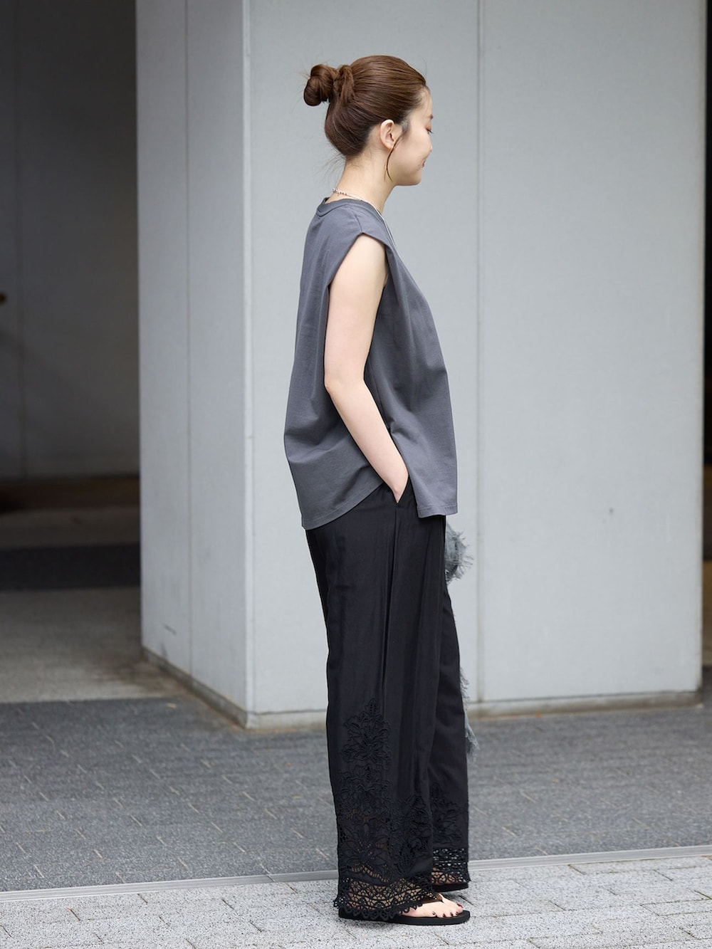 ブラック系のその他パンツ、グレー系のTシャツ/カットソー、ブラック系のサンダルを着用したレディースの春コーディネートの2枚目の写真