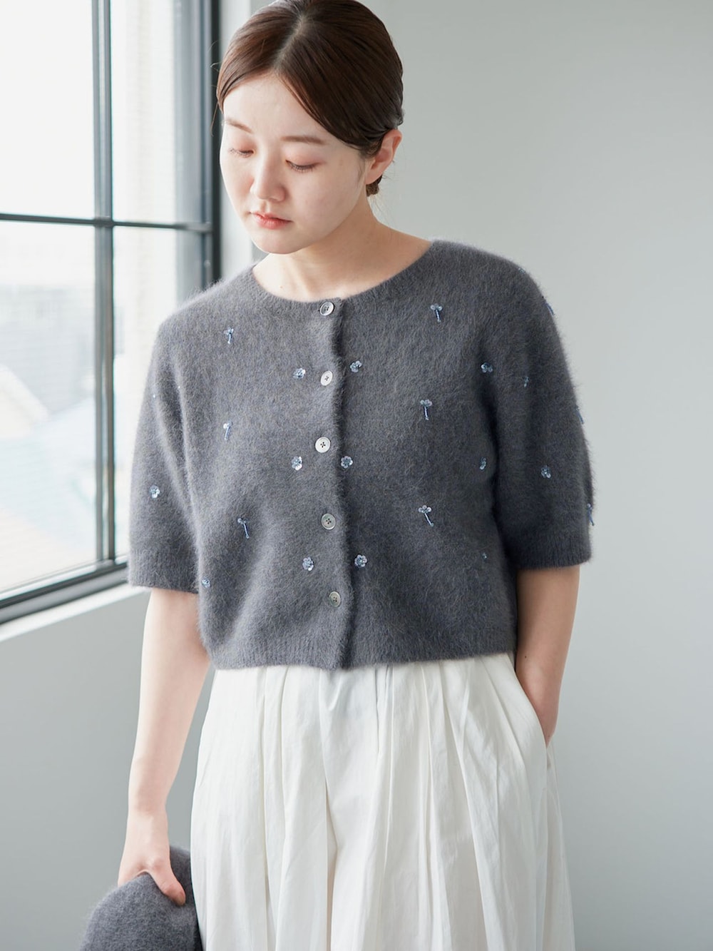 ホワイト系のスカート、グレー系のカーディガン/ボレロ、グレー系のバンダナ/スカーフを着用したレディースの秋コーディネートの3枚目の写真