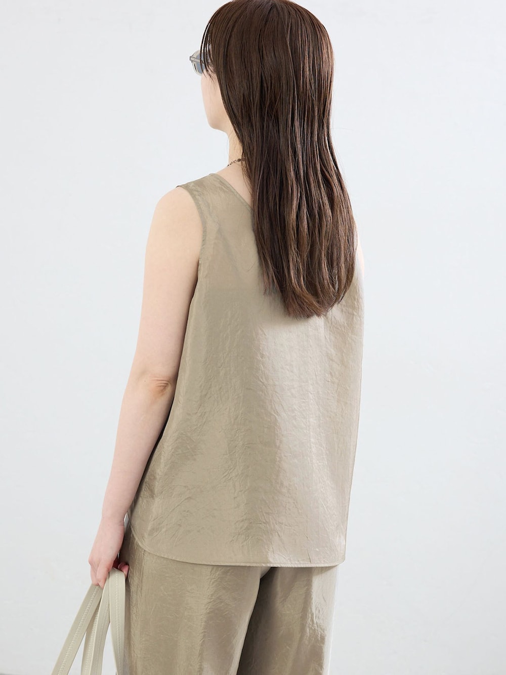 ベージュ系のその他パンツ、ベージュ系のシャツ/ブラウス、ブラウン系のトートバッグを着用したレディースの夏コーディネートの5枚目の写真