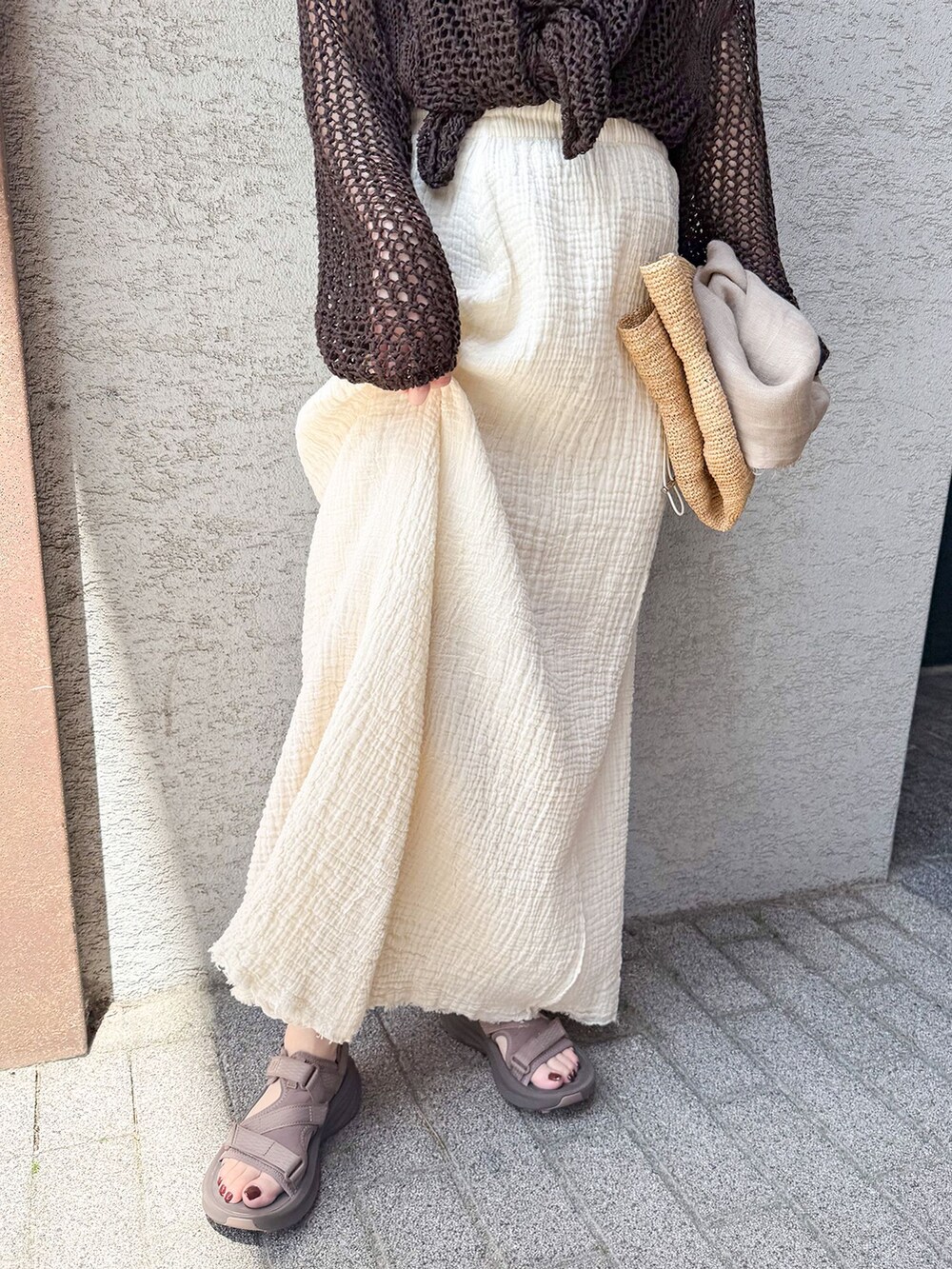 ブラウン系のニット/セーター、ブラウン系のサンダルを着用したレディースの春コーディネートの3枚目の写真