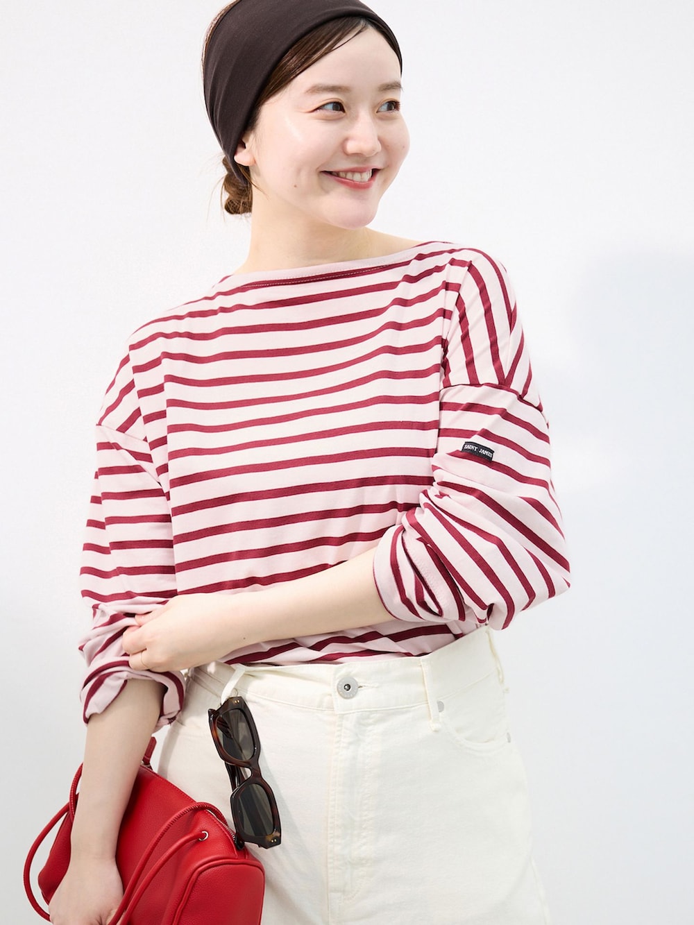 ホワイト系のチノパンツ、レッド系のショルダーバッグ、レッド系のパンプスを着用したレディースの夏コーディネートの4枚目の写真