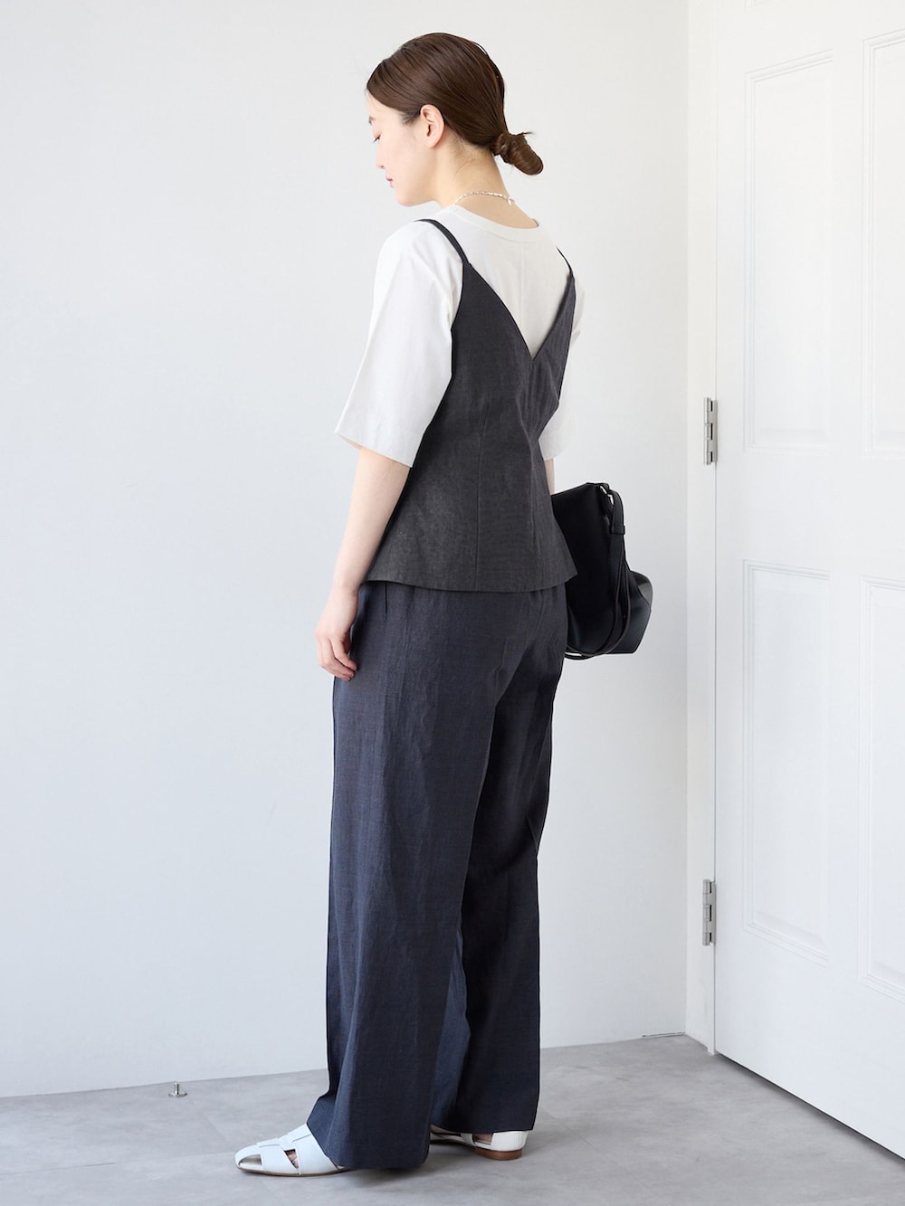 ブラック系のベスト、ブラック系のスラックス、ホワイト系のTシャツ/カットソーを着用したレディースの春コーディネートの2枚目の写真