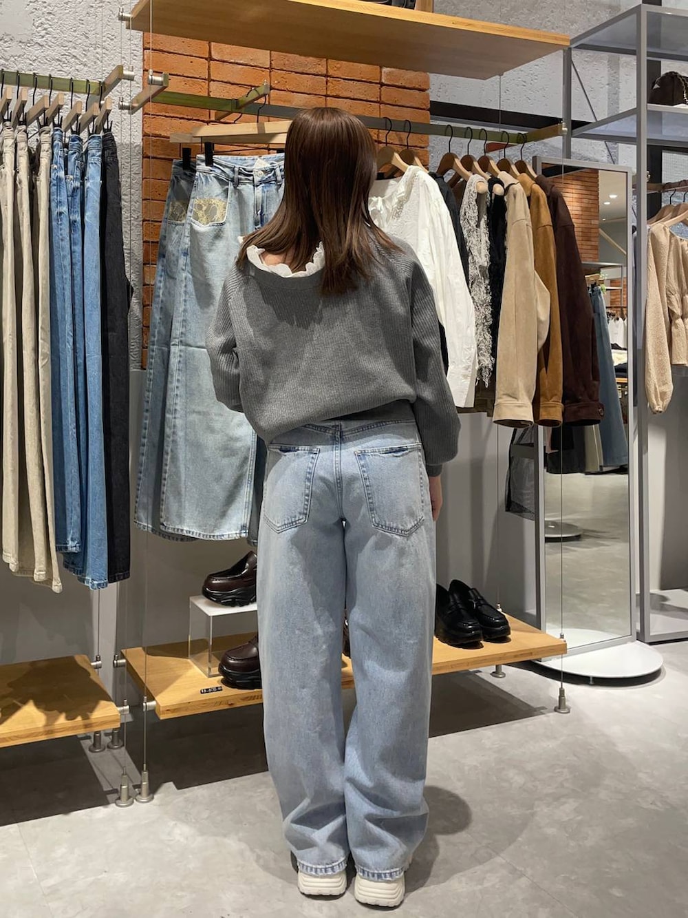 ブルー系のデニムパンツ、グレー系のカーディガン/ボレロ、ホワイト系のスニーカーを着用したレディースの冬コーディネートの2枚目の写真