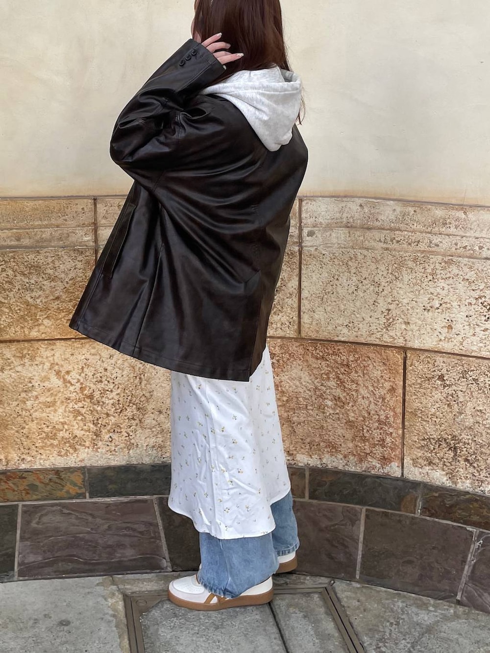 ホワイト系のスカート、ブラウン系のカバーオール、グレー系のパーカーを着用したレディースの春コーディネートの2枚目の写真