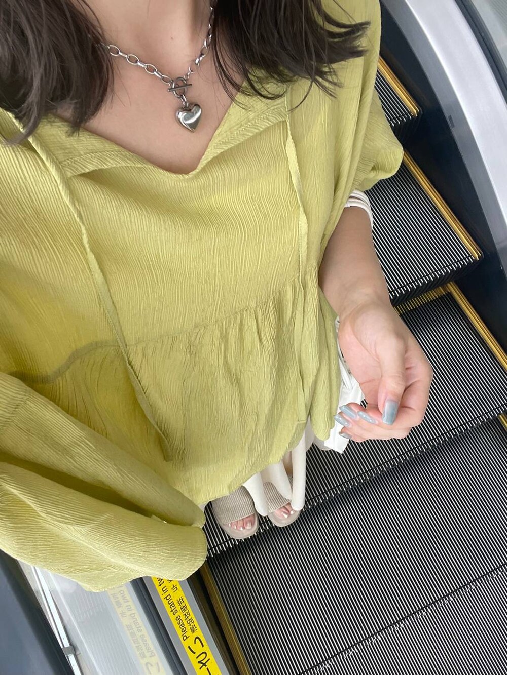 ホワイト系のサンダル、ホワイト系のショルダーバッグ、グリーン系のシャツ/ブラウスを着用したレディースの夏コーディネートの5枚目の写真