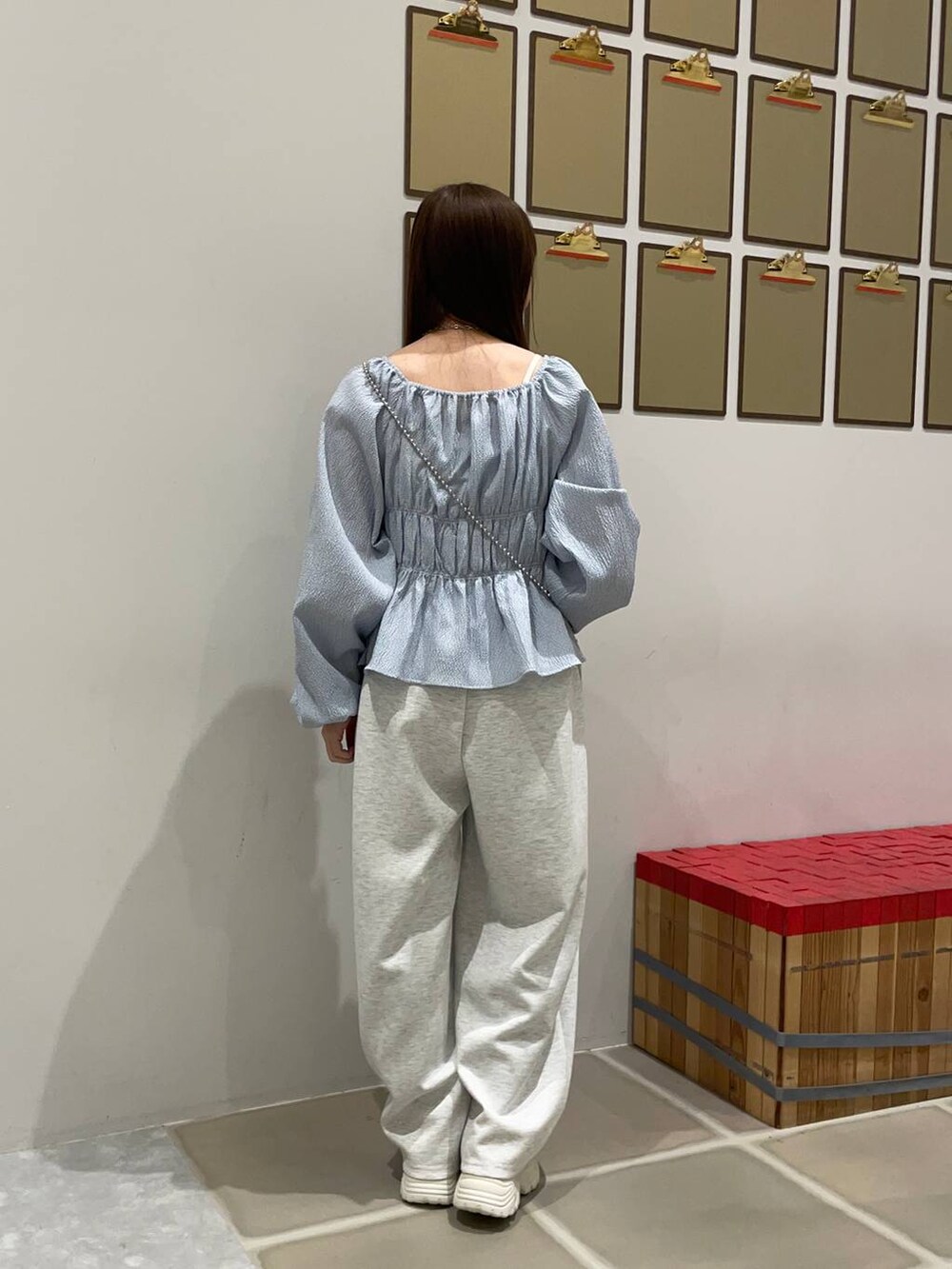 シルバー系のショルダーバッグ、グレー系のスウェットパンツ、ブルー系のTシャツ/カットソーを着用したレディースの冬コーディネートの2枚目の写真