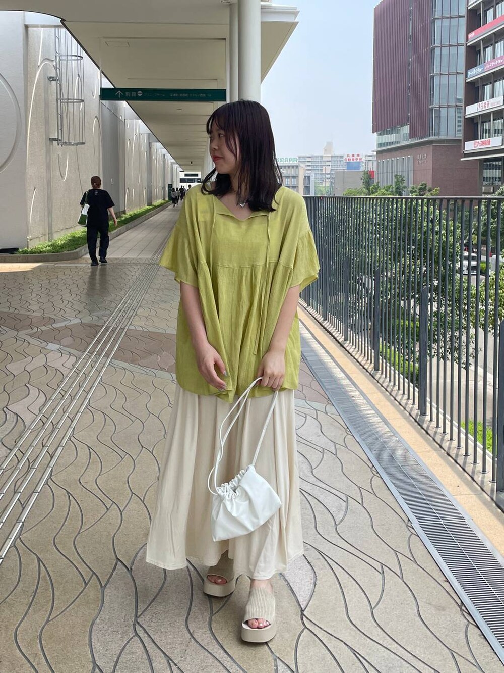 ホワイト系のサンダル、ホワイト系のショルダーバッグ、グリーン系のシャツ/ブラウスを着用したレディースの夏コーディネートの4枚目の写真