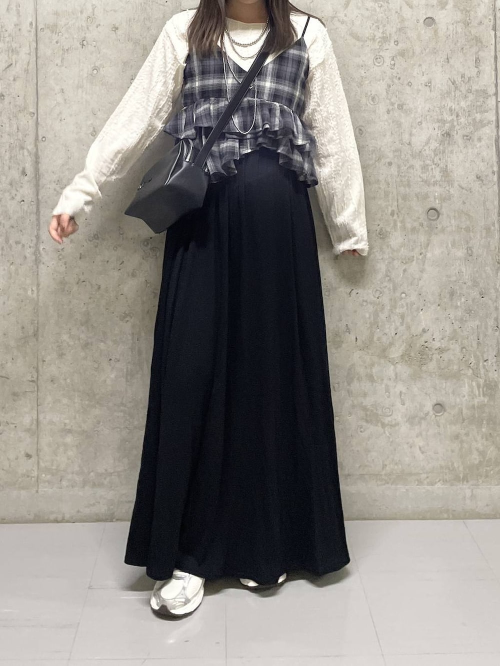 ベージュ系のTシャツ/カットソー、ブラック系のスカート、グレー系のキャミソールを着用したレディースの秋コーディネートの4枚目の写真