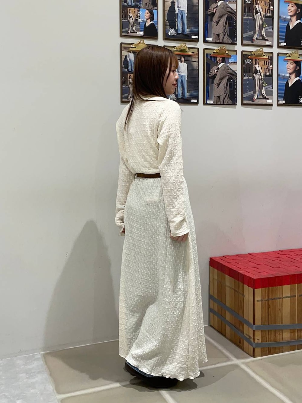 ブルー系のデニムパンツ、ブラウン系のスニーカー、ホワイト系のワンピースを着用したレディースの春コーディネートの2枚目の写真