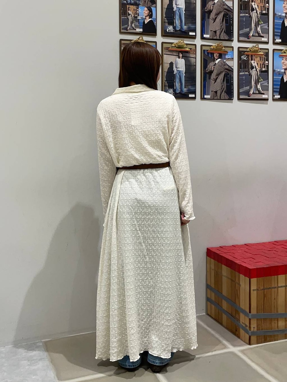 ブルー系のデニムパンツ、ブラウン系のスニーカー、ホワイト系のワンピースを着用したレディースの春コーディネートの3枚目の写真