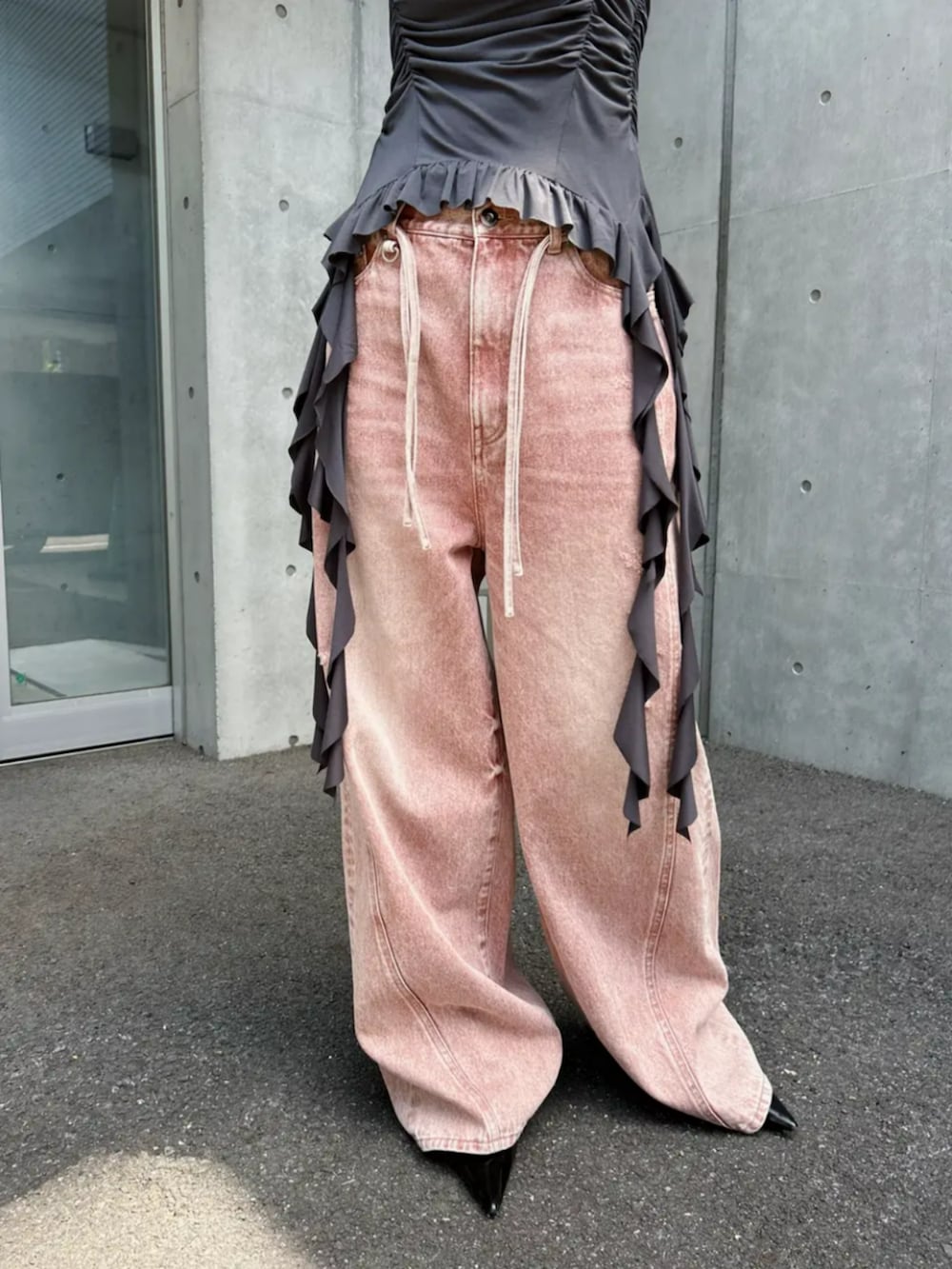 ブラック系のパンプス、ピンク系のデニムパンツ、グレー系のキャミソールを着用したレディースの春コーディネートの3枚目の写真