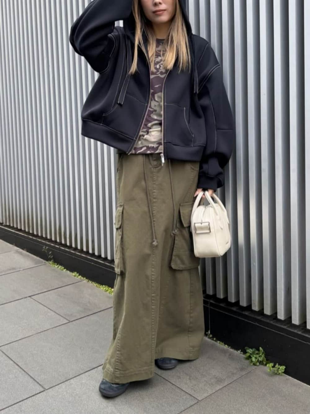 ブラック系のパーカー、ホワイト系のボストンバッグ、グリーン系のTシャツ/カットソーを着用したレディースの冬コーディネートの2枚目の写真