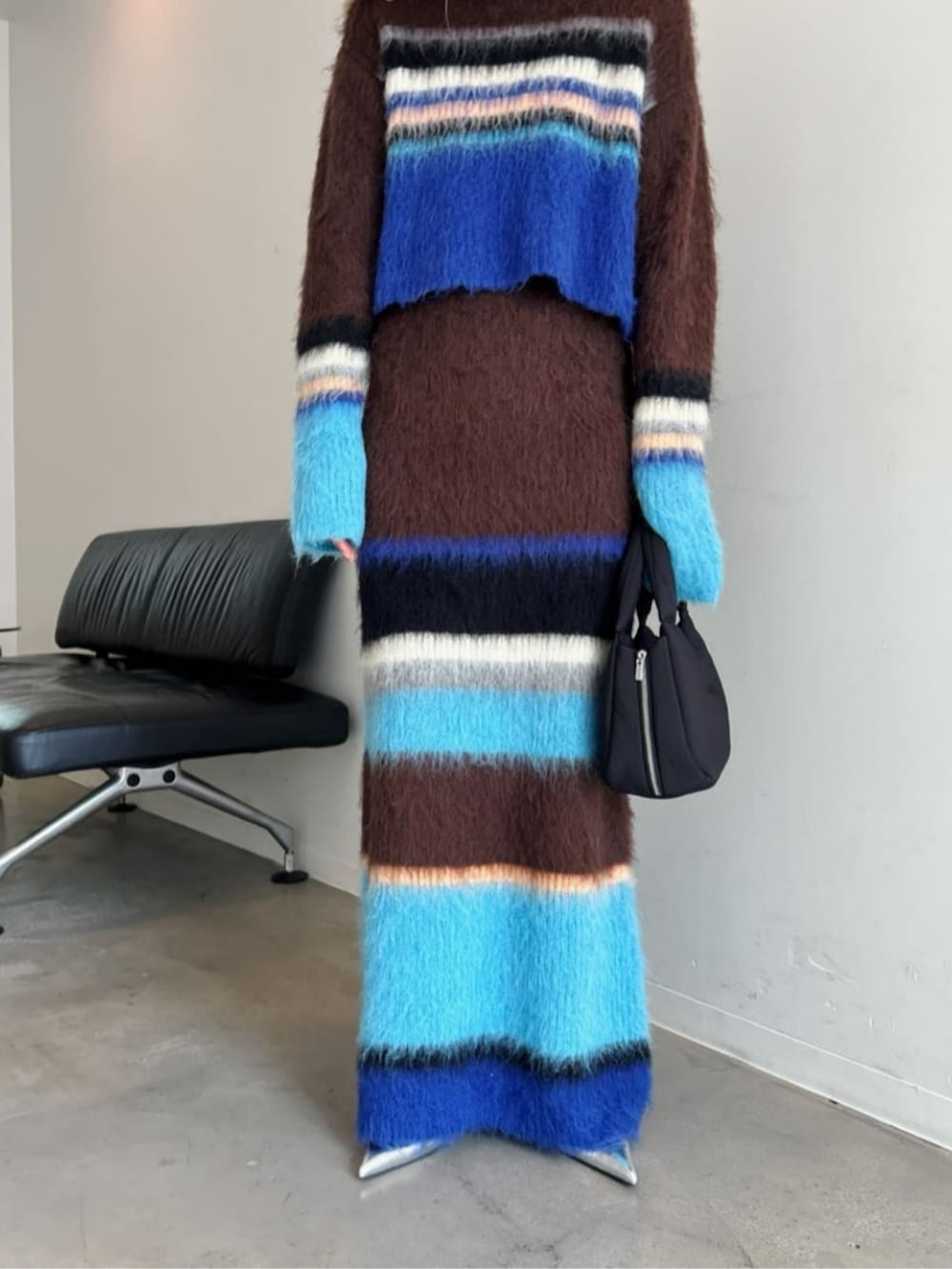 シルバー系のパンプス、ブラウン系のニット/セーター、ブラウン系のスカートを着用したレディースの秋コーディネートの3枚目の写真