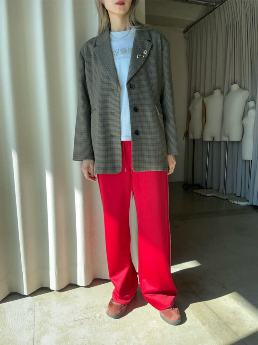 ブラウン系のテーラードジャケット、レッド系のスウェットパンツ、グレー系のTシャツ/カットソーを着用したレディースの冬コーディネートの2枚目の写真