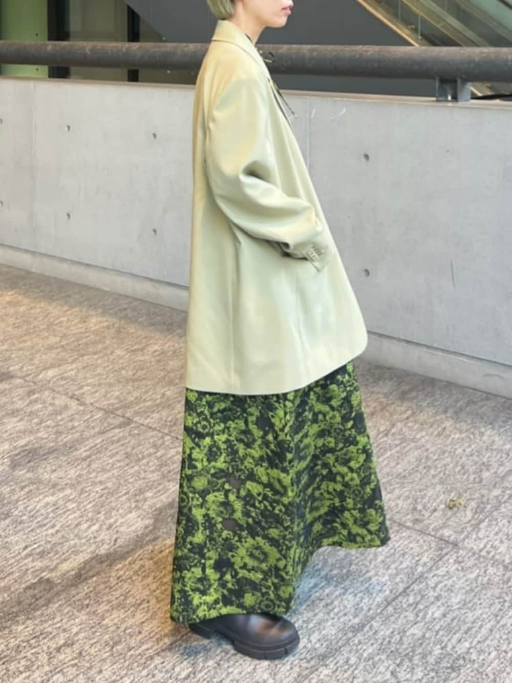 グリーン系のワンピース、グリーン系のテーラードジャケット、グレー系のタンクトップを着用したレディースの冬コーディネートの3枚目の写真