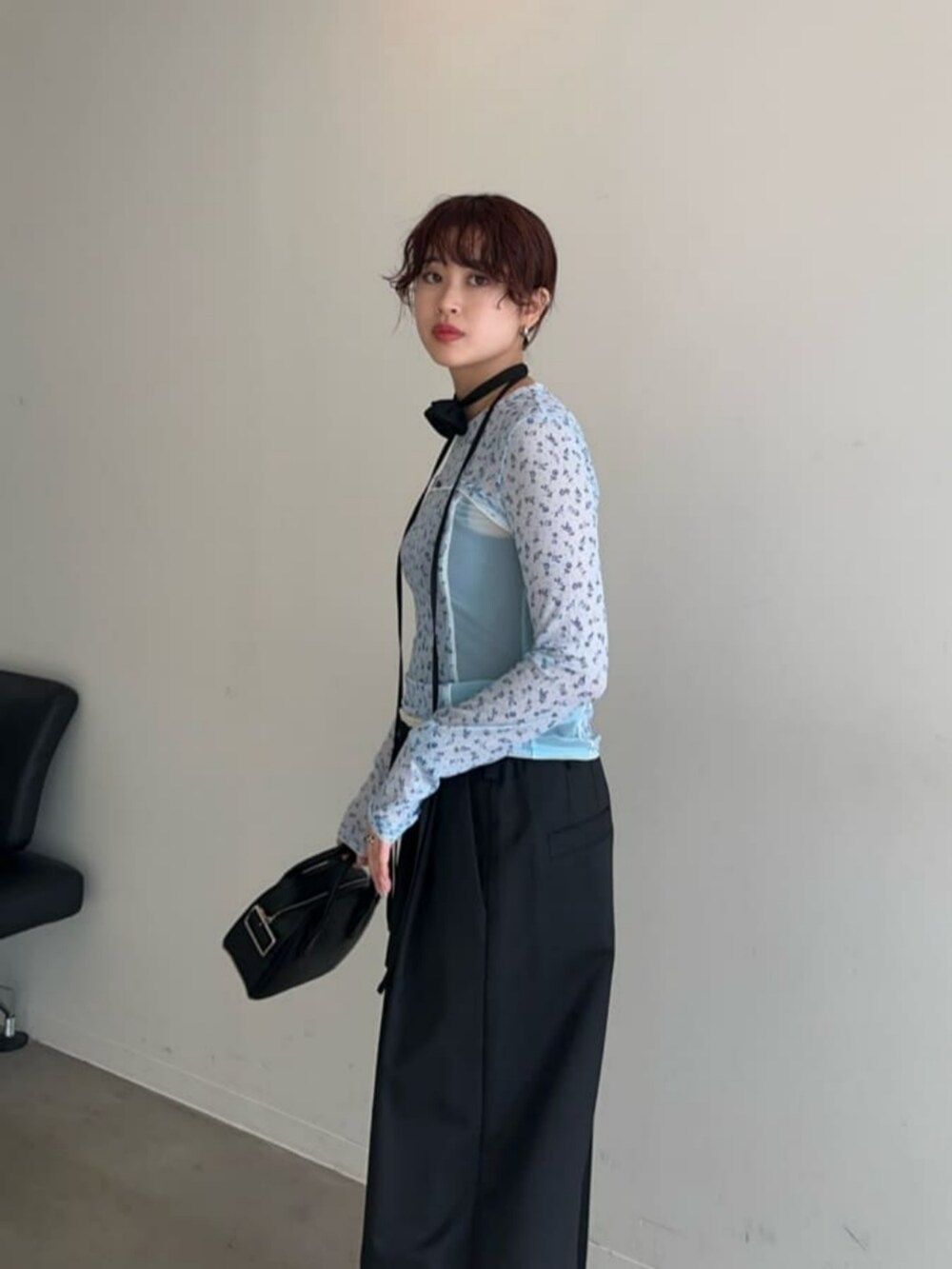ブラック系のボストンバッグ、シルバー系のパンプス、ブルー系のTシャツ/カットソーを着用したレディースの冬コーディネートの2枚目の写真