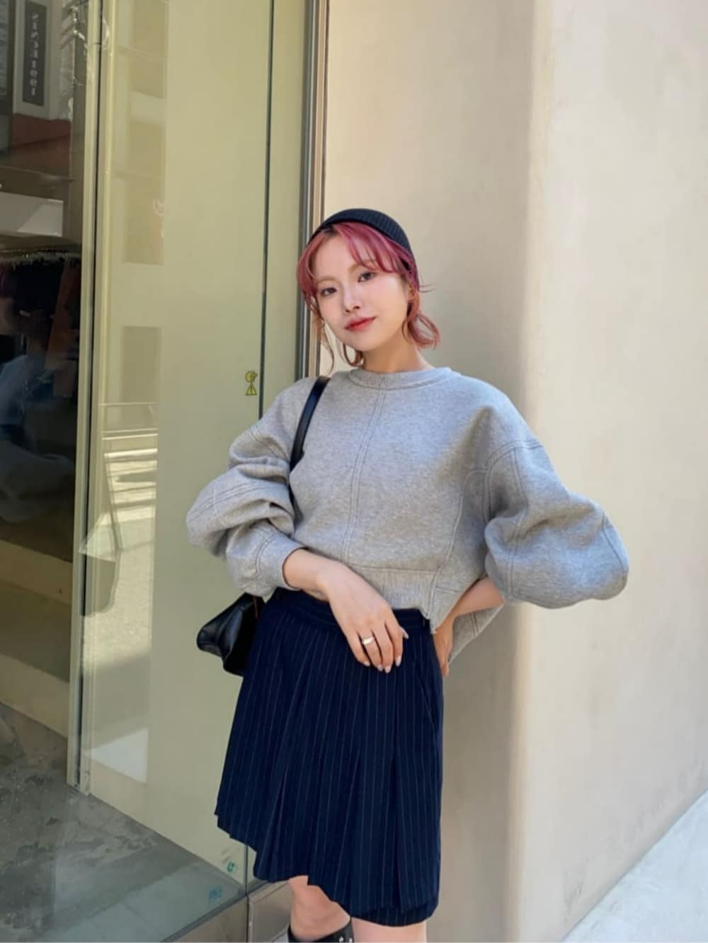 ブラック系のショルダーバッグ、ブラック系のブーツ、グレー系のスウェットを着用したレディースの秋コーディネートの2枚目の写真