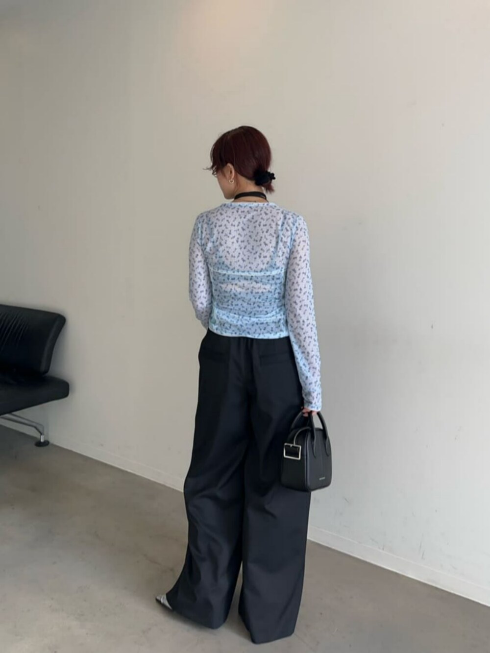 ブラック系のボストンバッグ、シルバー系のパンプス、ブルー系のTシャツ/カットソーを着用したレディースの冬コーディネートの4枚目の写真