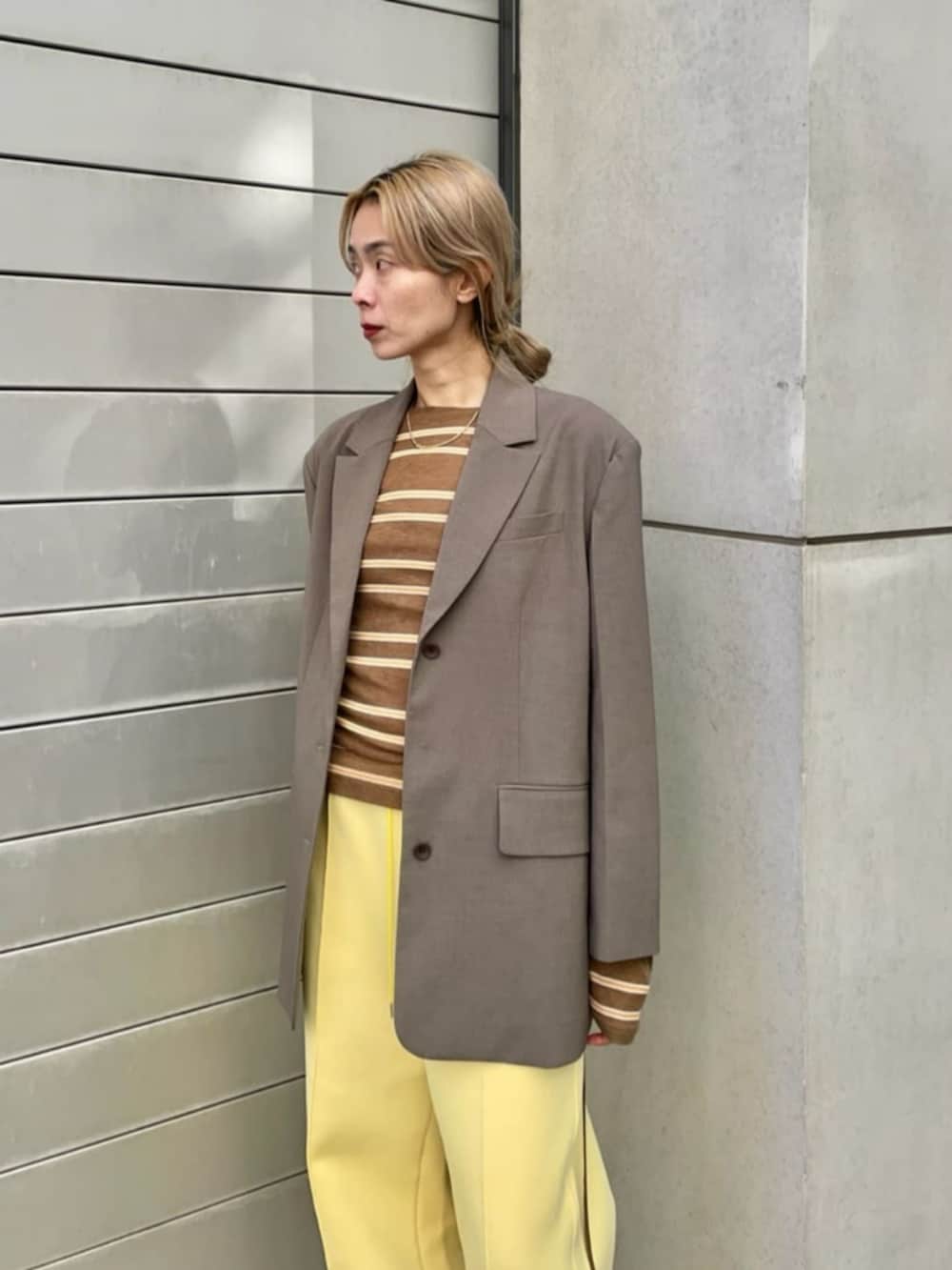 ブラウン系のテーラードジャケット、ベージュ系のTシャツ/カットソー、イエロー系のスウェットパンツを着用したレディースの冬コーディネートの2枚目の写真