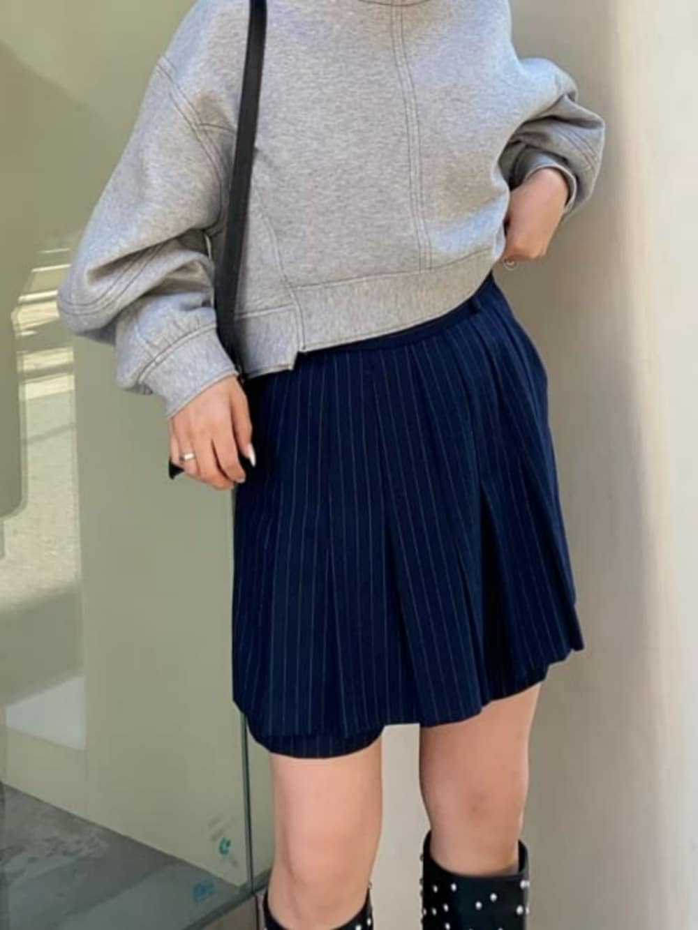 ブラック系のショルダーバッグ、ブラック系のブーツ、グレー系のスウェットを着用したレディースの秋コーディネートの3枚目の写真