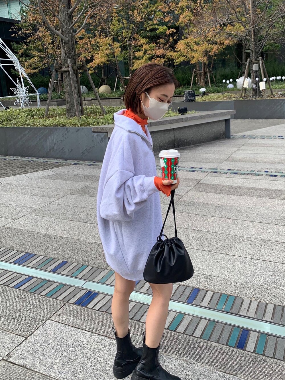 グレー系のスウェット、オレンジ系のTシャツ/カットソーを着用したレディースの冬コーディネートの2枚目の写真