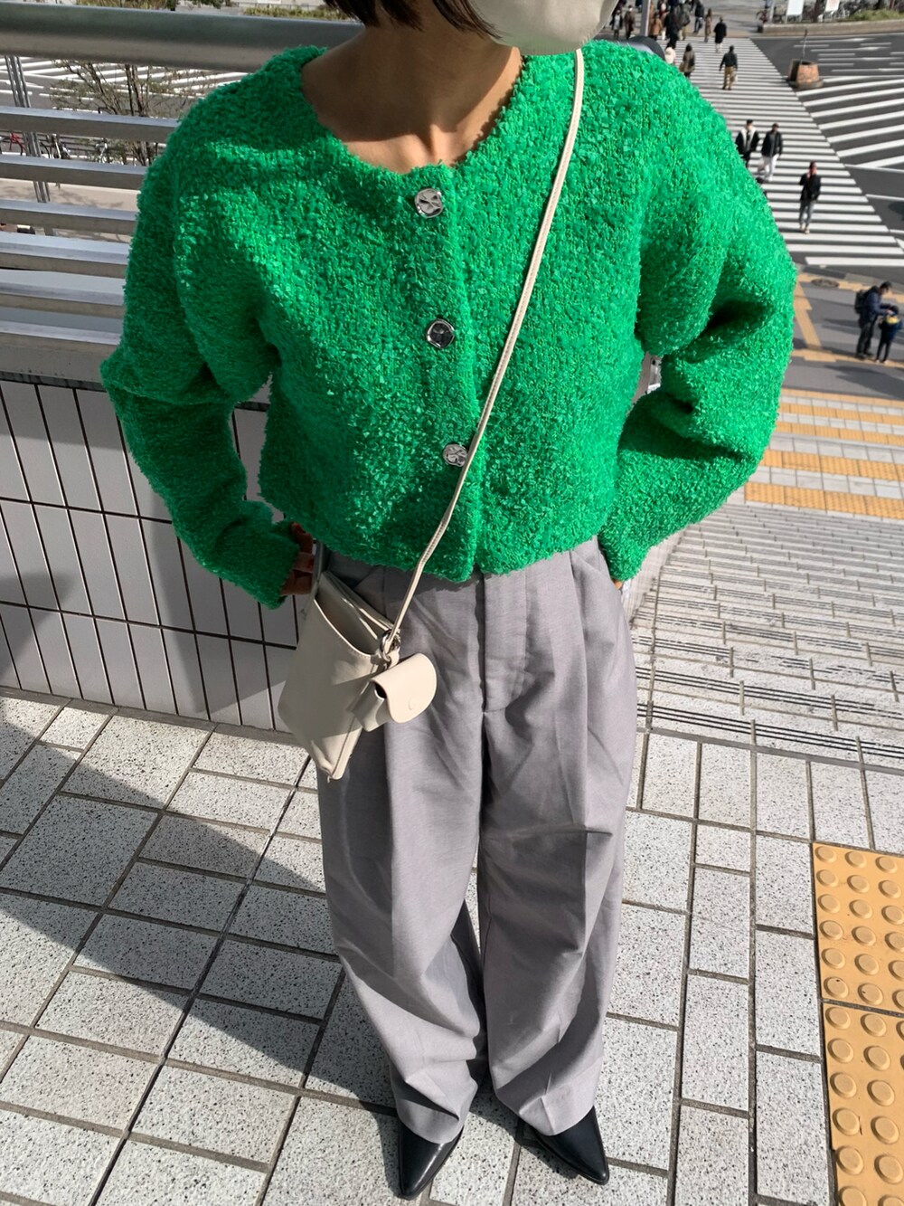 ホワイト系のカーディガン/ボレロ、グレー系のスラックスを着用したレディースの冬コーディネートの2枚目の写真