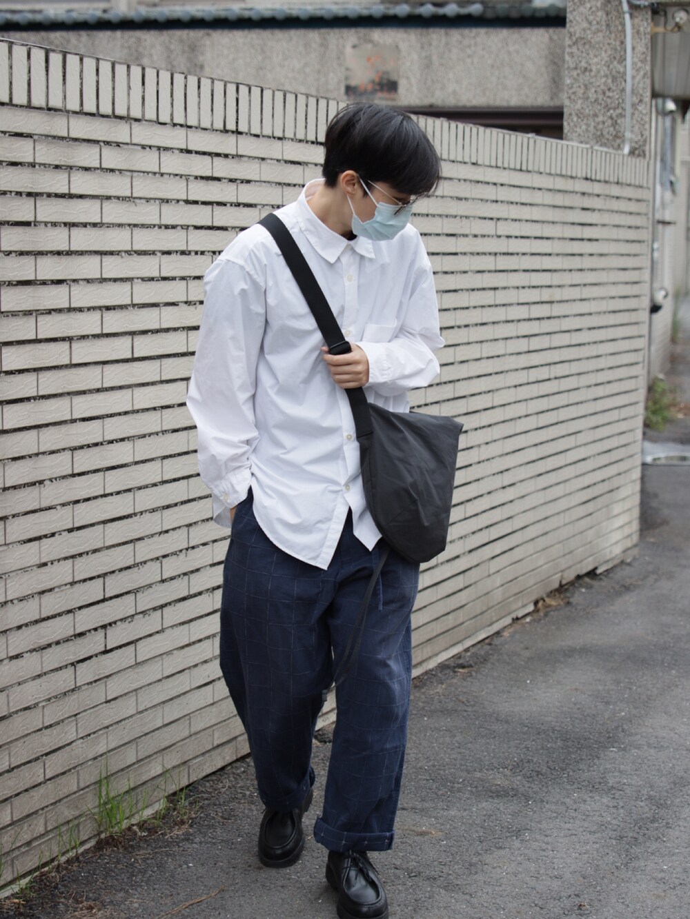 ブルー系のチノパンツ、ブラック系のバッグ、ホワイト系のシャツ/ブラウスを着用したメンズの冬コーディネートの2枚目の写真