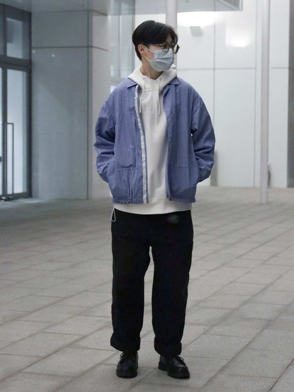 ブルー系のシャツ/ブラウス、グレー系のチノパンツ、ブラック系のシューズを着用したメンズの春コーディネートの2枚目の写真