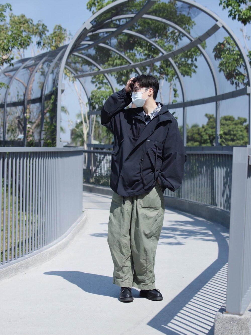 ブルー系のジャケット/アウター、グリーン系のチノパンツ、ブラック系のシューズを着用したメンズの春コーディネートの2枚目の写真