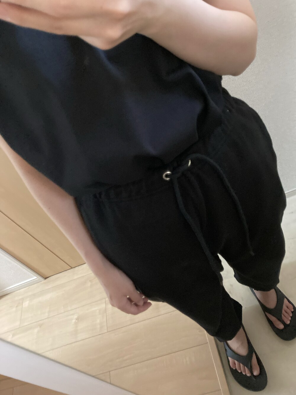 ブラック系のタンクトップ、ブラック系のスウェットパンツ、ブラック系のサンダルを着用したレディースの夏コーディネートの2枚目の写真