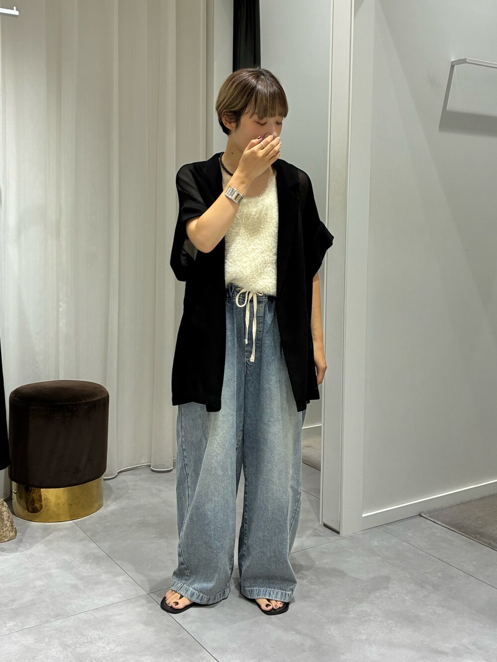 ブルー系のデニムパンツ、ホワイト系のニット/セーター、ブラック系のテーラードジャケットを着用したレディースの夏コーディネートの3枚目の写真