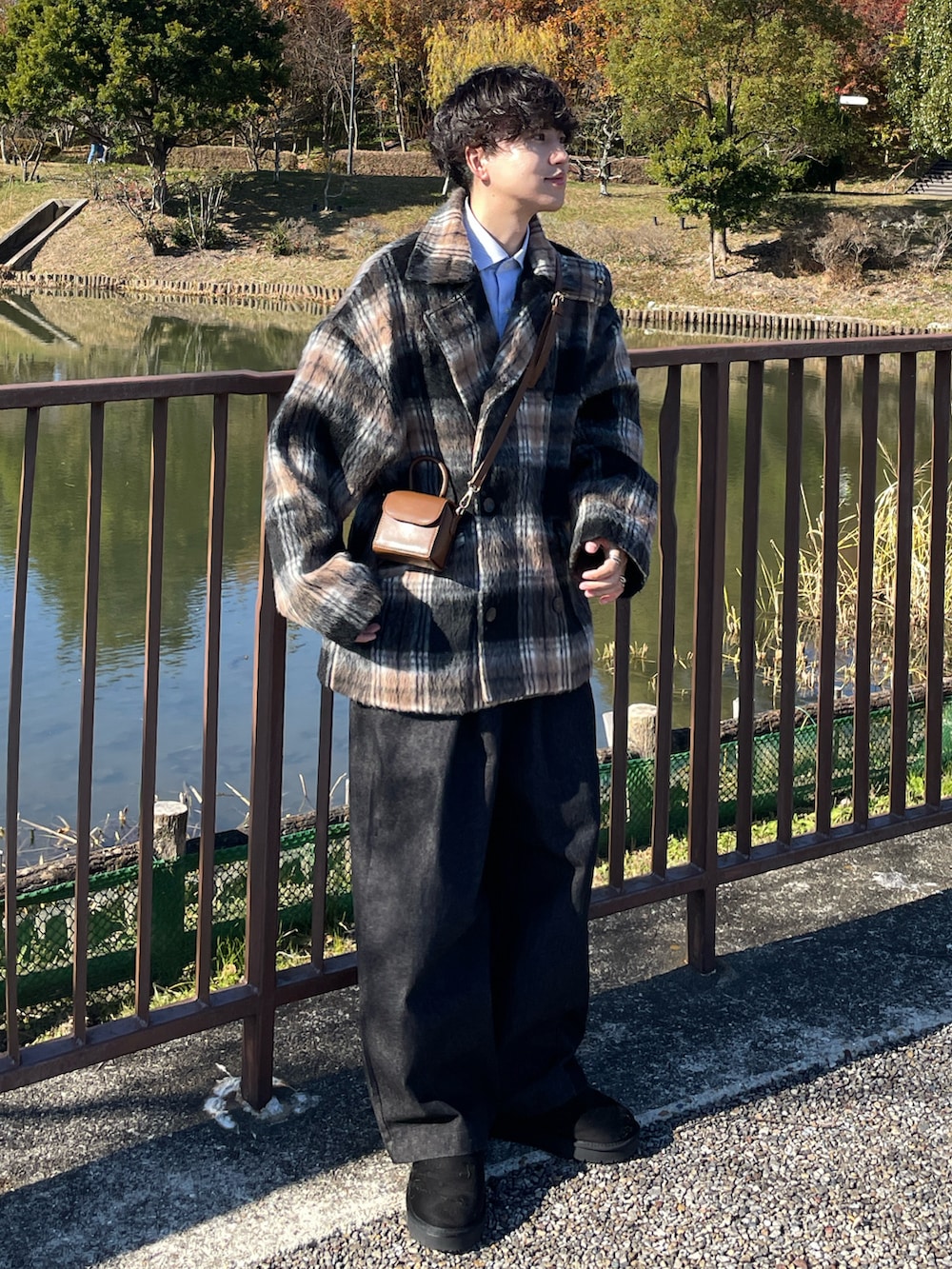 ブラウン系のジャケット/アウター、ブラウン系のバッグ、ブラック系のデニムパンツを着用したメンズの冬コーディネートの2枚目の写真