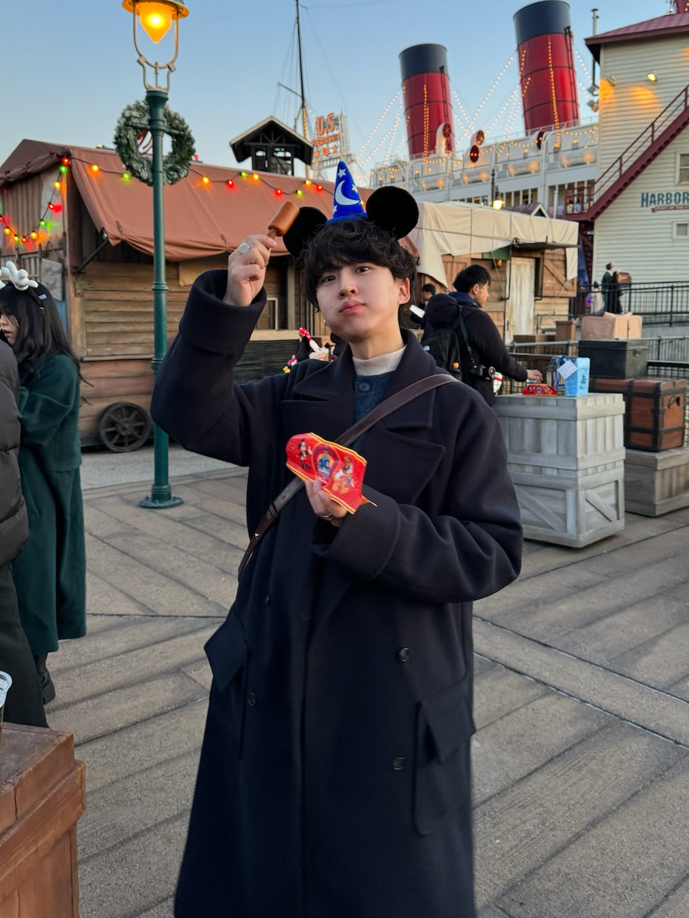 グレー系のパンツ、ブルー系のカーディガン/ボレロ、ブラック系のブーツを着用したメンズの冬コーディネートの2枚目の写真