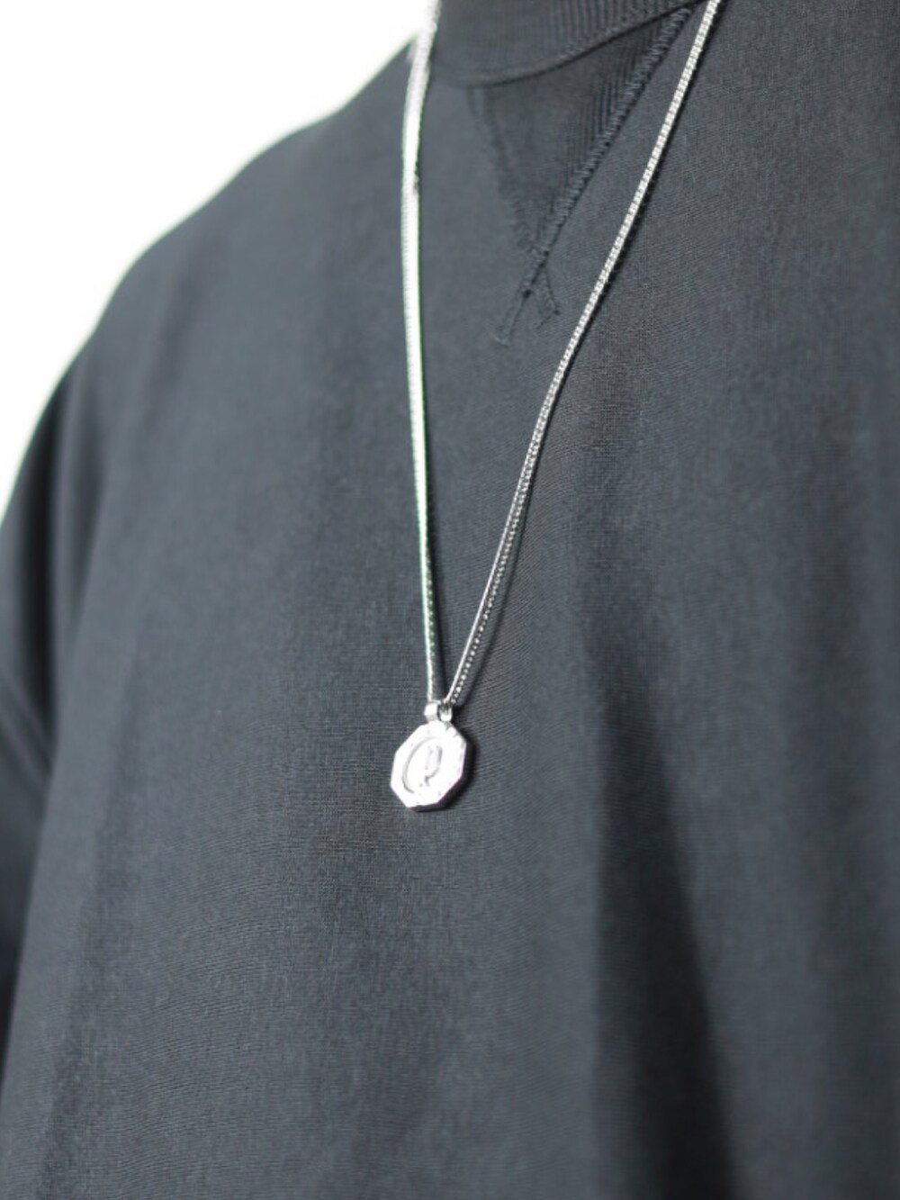 ベージュ系のチノパンツ、ブラック系のTシャツ/カットソー、ホワイト系のタンクトップを着用したメンズの春コーディネートの2枚目の写真