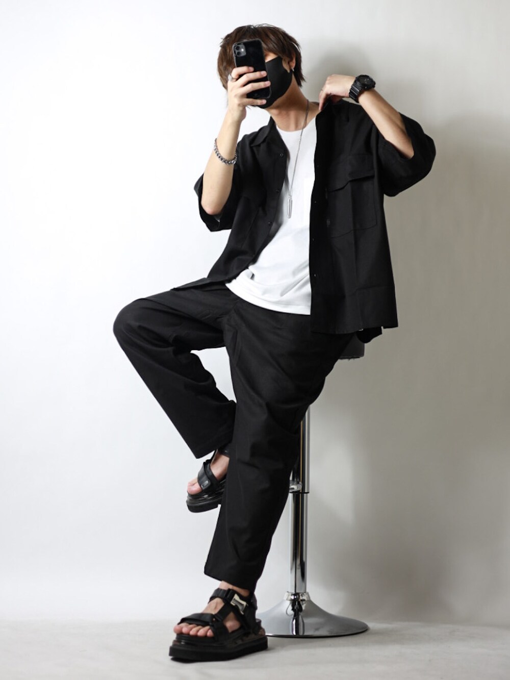 ブラック系のセットアップ、ホワイト系のTシャツ/カットソー、ブラック系のサンダルを着用したメンズの春コーディネートの2枚目の写真