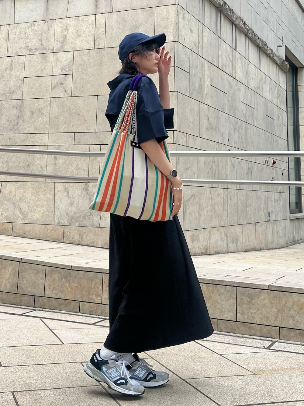 ブラック系のワンピース、ブルー系のシャツ/ブラウス、グレー系のスニーカーを着用したレディースの夏コーディネートの2枚目の写真