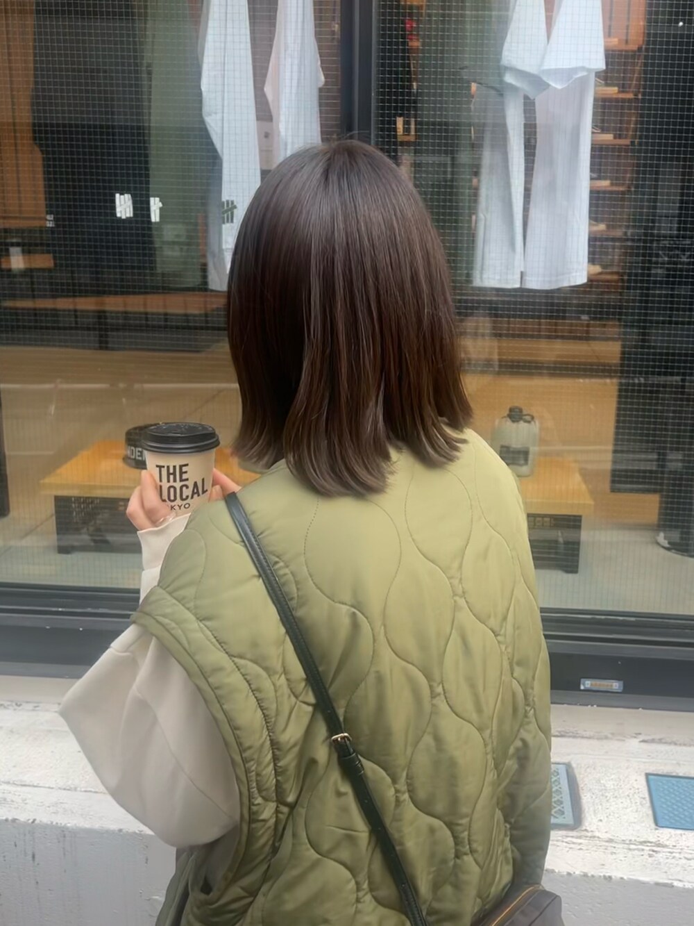 グリーン系のノーカラージャケット、ベージュ系のTシャツ/カットソーを着用したレディースの春コーディネートの2枚目の写真