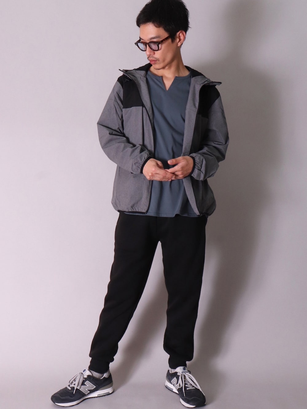 グリーン系のナイロンジャケット、ブラック系のスニーカー、グレー系のスウェットパンツを着用したメンズの春コーディネートの5枚目の写真