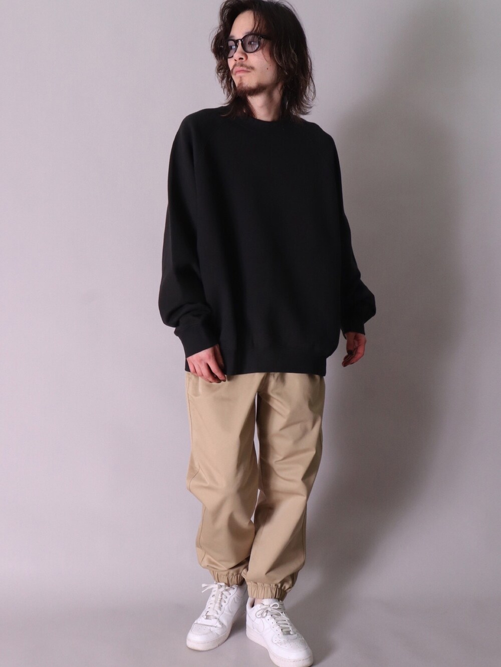 ベージュ系のスウェット、ブラック系のスウェット、ブルー系のデニムパンツを着用したレディースの春コーディネートの4枚目の写真