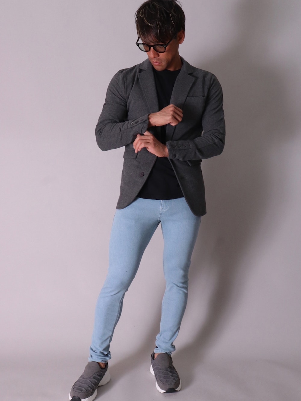 ブラック系のテーラードジャケット、ホワイト系のTシャツ/カットソー、ブラック系のデニムパンツを着用したメンズの冬コーディネートの2枚目の写真