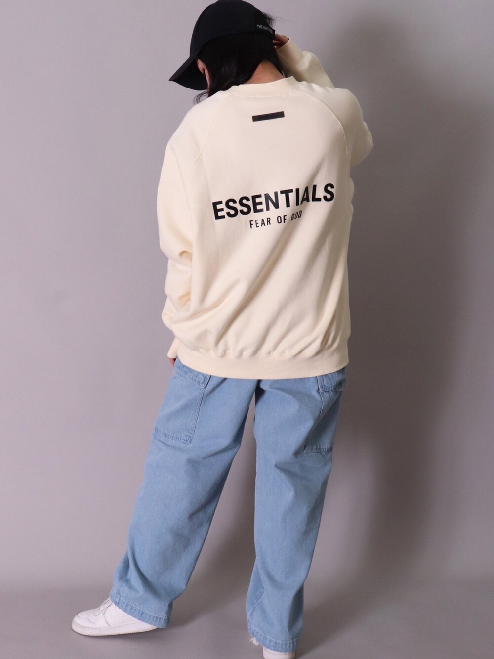 ベージュ系のスウェット、ブラック系のスウェット、ブルー系のデニムパンツを着用したレディースの春コーディネートの2枚目の写真