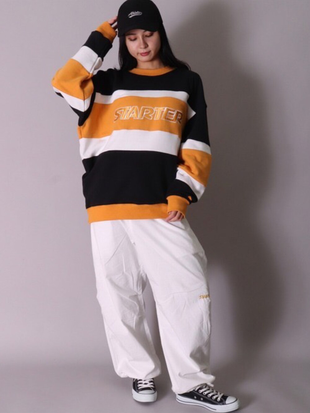 ブラック系のスウェット、ホワイト系のTシャツ/カットソー、ホワイト系のスニーカーを着用したレディースの冬コーディネートの5枚目の写真