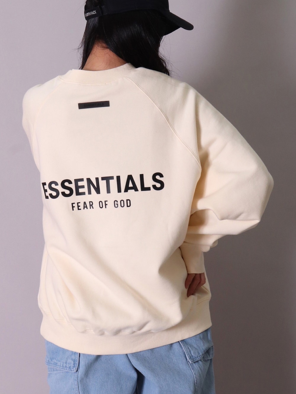 ベージュ系のスウェット、ブラック系のスウェット、ブルー系のデニムパンツを着用したレディースの春コーディネートの3枚目の写真