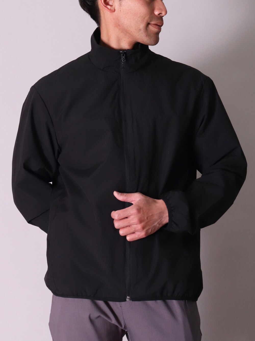 グレー系のナイロンジャケット、ブラック系のカーゴパンツ、ブラック系のナイロンジャケットを着用したレディースの冬コーディネートの2枚目の写真