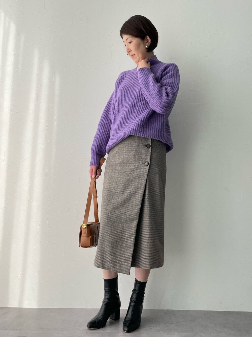 ブラウン系のスカート、ブラウン系のダウンジャケット/コート、パープル系のニット/セーターを着用したレディースの冬コーディネートの3枚目の写真