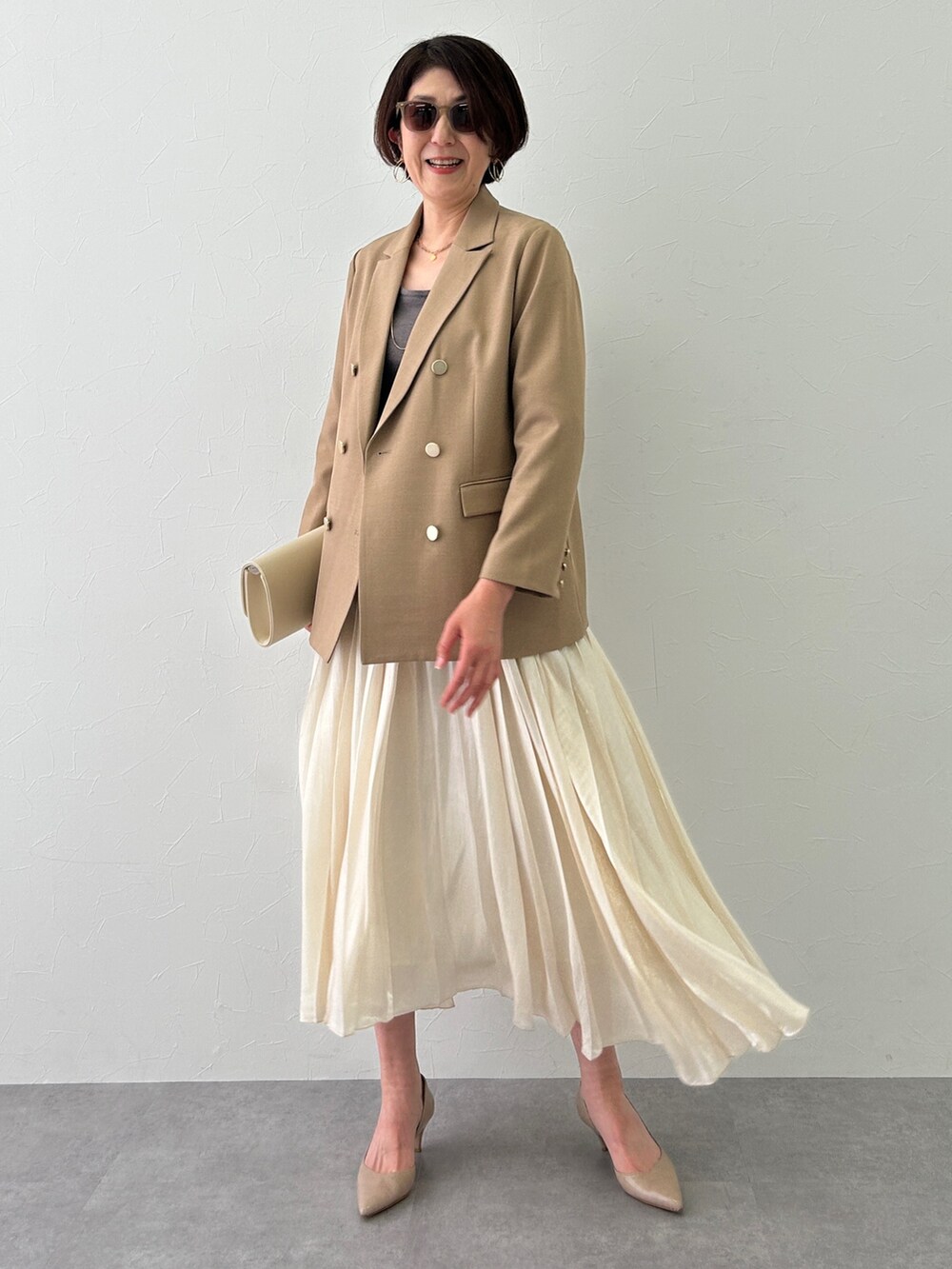 ブラウン系のジャケット/アウター、ブラウン系のニット/セーター、ホワイト系のスカートを着用したレディースの冬コーディネートの2枚目の写真